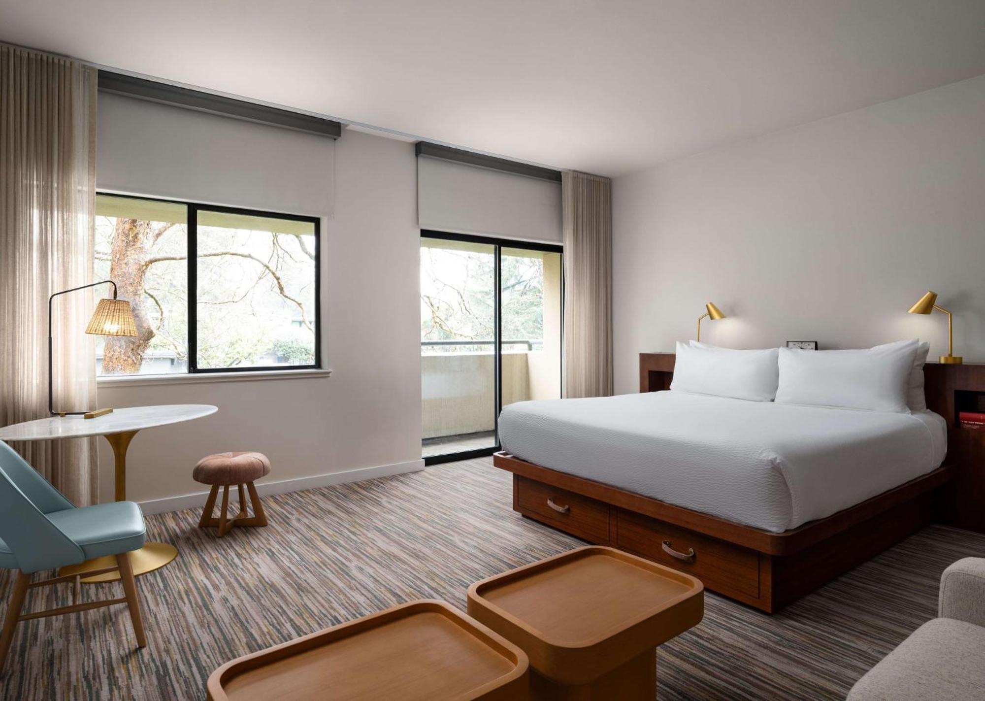 Habitación con cama extragrande, sofá cama y vistas a la piscina